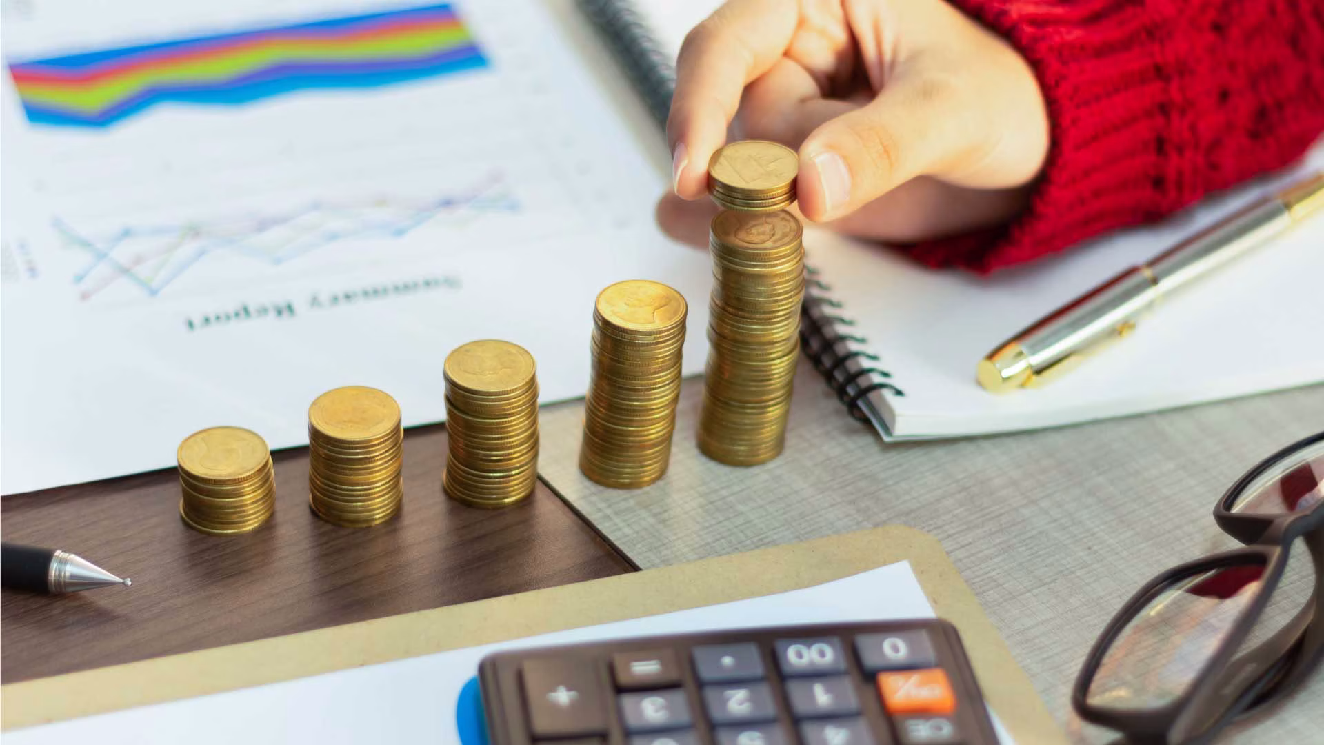 Rising stacks of coins beside a financial report, representing interest on a loan